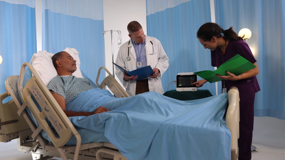brio-x30-patient-monitor-in-clinical-use Brio X30 patient monitor in clinical use at bedside with clinicians reviewing vital signs of a patient