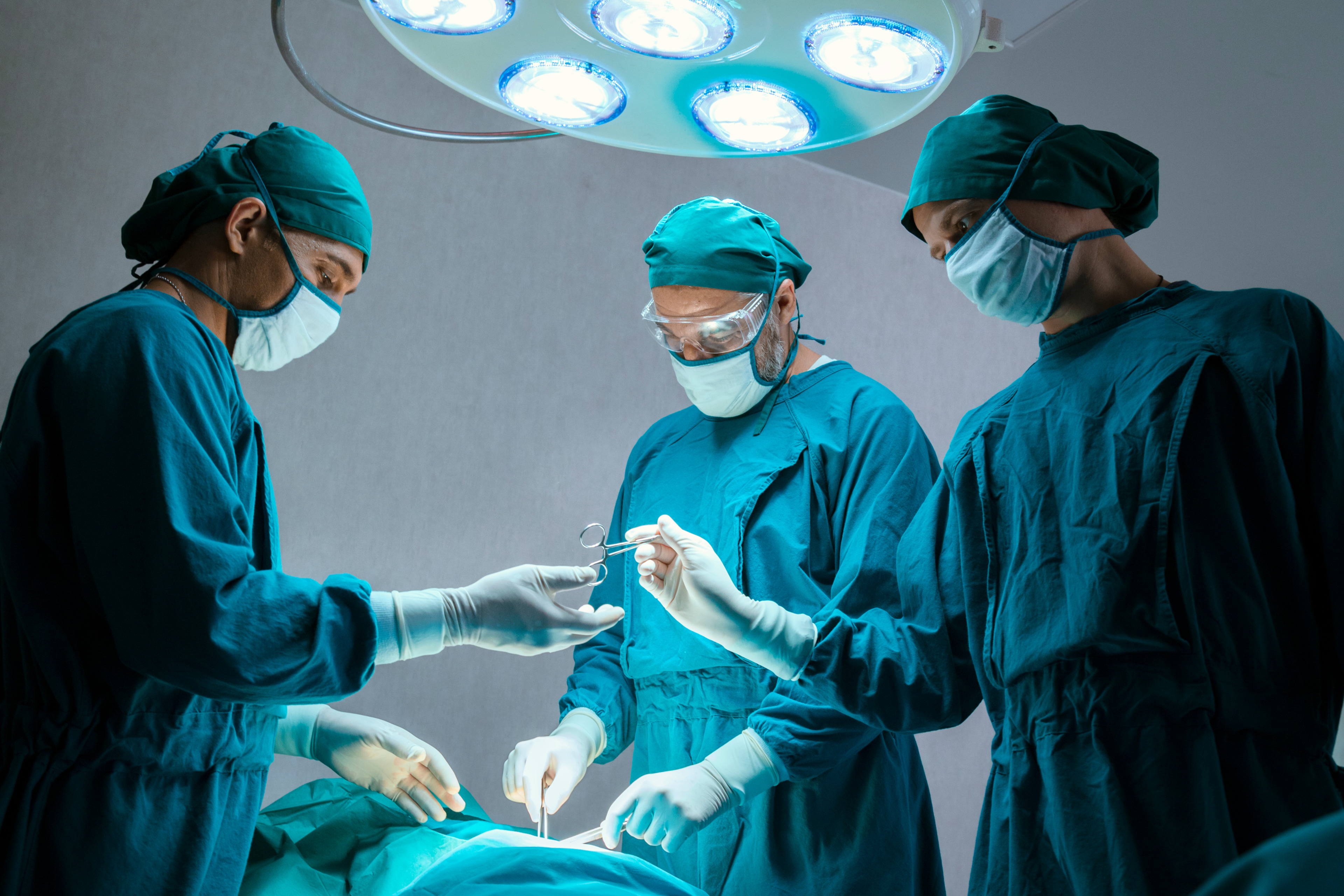 Surgical team performing a medical procedure in a modern operating room using advanced healthcare equipment