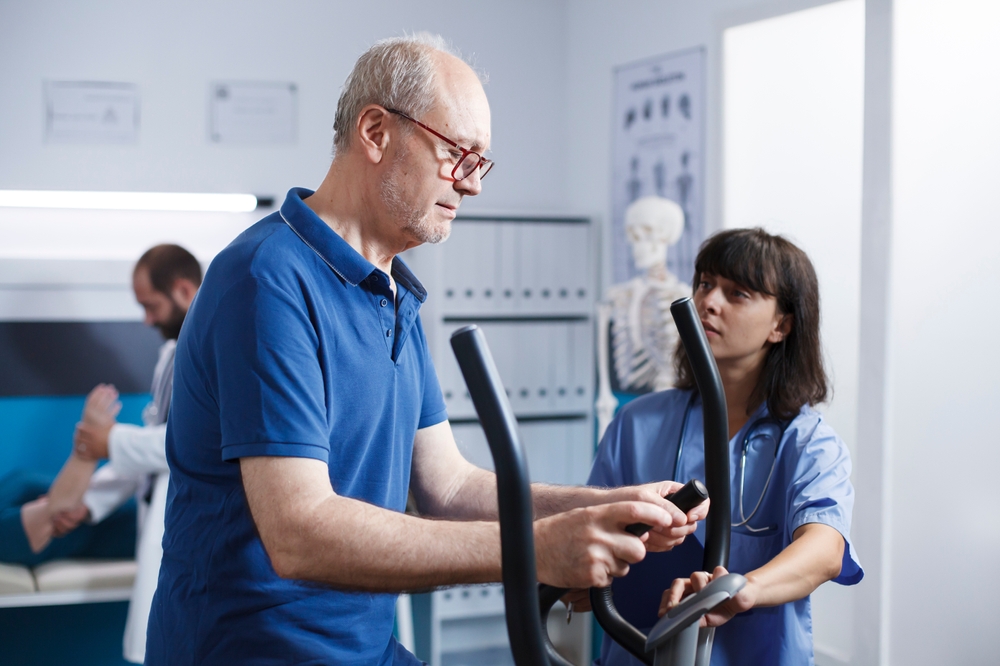 Senior patient receiving rehabilitation therapy under healthcare professional supervision in a clinical setting
