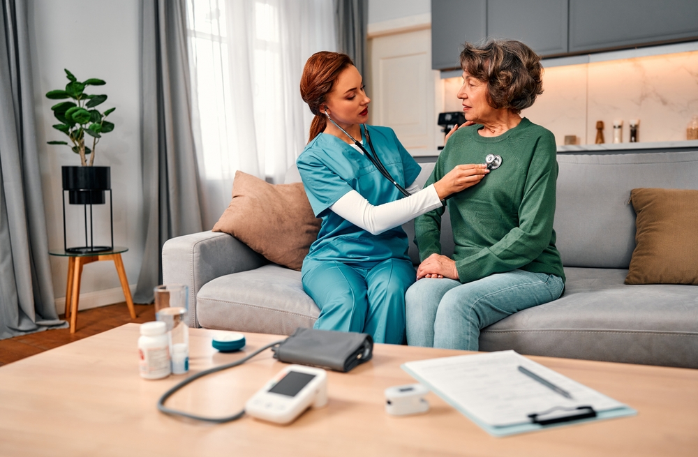 Healthcare professional assessing an elderly patient's cardiovascular health during a home healthcare visit