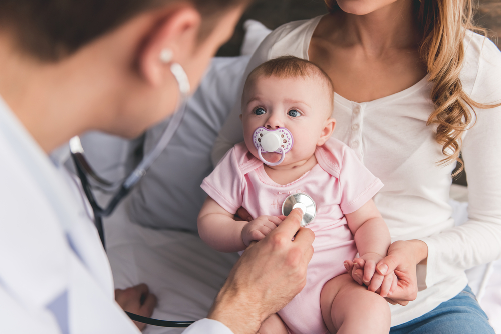 Healthcare professional conducting a pediatric health examination for an infant in a family healthcare setting